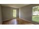 Bedroom with two windows, wood-look flooring, and neutral color palette at 2503 Elm St, Seffner, FL 33584