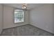 Cozy bedroom featuring neutral carpet and a large window with views of the outdoors at 3633 Springville Dr, Valrico, FL 33596