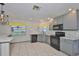 Charming kitchen features grey cabinets, sleek black appliances, and light tile floors at 3633 Springville Dr, Valrico, FL 33596