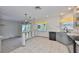 Well-lit kitchen showcasing gray cabinetry, updated countertops, breakfast bar, and a seamless transition to a dining area at 3633 Springville Dr, Valrico, FL 33596