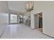 Spacious open-concept living area with tiled floors, staircase, chandelier and natural light at 3633 Springville Dr, Valrico, FL 33596