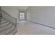 Bright and airy living room featuring high ceilings, large windows, neutral tiling and a carpeted staircase at 3633 Springville Dr, Valrico, FL 33596