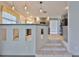 Staircase from living room leads to a modern kitchen with grey cabinets and black appliances at 3633 Springville Dr, Valrico, FL 33596
