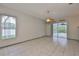 Open living room with tile floors, ceiling fan, and sliding doors to outdoor patio at 3633 Springville Dr, Valrico, FL 33596