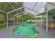 A refreshing screened-in pool area featuring unique tile accents, a swim-up bar, and lush greenery at 3633 Springville Dr, Valrico, FL 33596