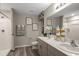 This bright bathroom features a double vanity, framed art, and a shower-tub combination at 37106 Sagemoor Dr, Zephyrhills, FL 33541