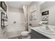Bright bathroom features a shower-tub combo, framed art, and a stylish gray vanity at 37106 Sagemoor Dr, Zephyrhills, FL 33541