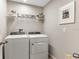 Neat laundry room with modern washer and dryer, shelving, and decor at 37106 Sagemoor Dr, Zephyrhills, FL 33541