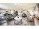 Open-concept floor plan features a living room with gray sofas and an eat-in kitchen at 37106 Sagemoor Dr, Zephyrhills, FL 33541