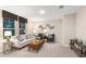 A well-lit living room has a large window, modern art, and a sofa complemented by stylish furniture at 37106 Sagemoor Dr, Zephyrhills, FL 33541