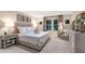 The primary bedroom features ample natural light, a king bed, and tasteful neutral decor at 37106 Sagemoor Dr, Zephyrhills, FL 33541
