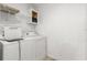 Functional laundry room with washer, dryer, shelving, and cabinet storage for added convenience at 3953 10Th S Ave, St Petersburg, FL 33711