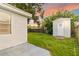 Spacious backyard featuring a storage shed, green grass, and fenced perimeter, providing privacy and room for outdoor activities at 4318 Mesa Dr, New Port Richey, FL 34653