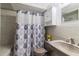 Well-lit bathroom with shower/tub combo, modern vanity, cabinet storage, and decorative shower curtain at 4318 Mesa Dr, New Port Richey, FL 34653