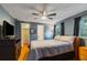 Spacious bedroom features ceiling fan, TV, walk-in closet, ensuite bath, and window with bright natural light at 4318 Mesa Dr, New Port Richey, FL 34653