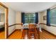 Bright dining room featuring wood floors, neutral wall paint, and large windows with decorative curtains at 4318 Mesa Dr, New Port Richey, FL 34653