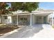 Charming single-story home featuring a covered carport, lush tree, and neutral-colored exterior paint at 4318 Mesa Dr, New Port Richey, FL 34653