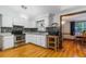 Bright kitchen with white cabinets, stainless steel appliances, decorative backsplash, and wood grain flooring at 4318 Mesa Dr, New Port Richey, FL 34653