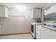 Functional laundry room featuring washer, dryer, cabinetry, and window providing natural light at 4318 Mesa Dr, New Port Richey, FL 34653