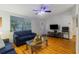 Inviting living room showcasing wood floors, a ceiling fan, a decorative front door, and natural light at 4318 Mesa Dr, New Port Richey, FL 34653