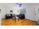 Cozy living room with wood floors, comfortable seating, a ceiling fan, and a decorative front door at 4318 Mesa Dr, New Port Richey, FL 34653