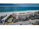 Aerial view of beachfront condo building with tennis court, parking and easy beach access at 4450 Gulf Blvd # 110, St Pete Beach, FL 33706