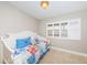 Cozy bedroom with a twin bed, tiled floor, white shutters and an abundance of natural light at 4450 Gulf Blvd # 110, St Pete Beach, FL 33706
