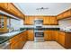 This kitchen is equipped with stainless steel appliances, wood cabinets, and granite counters at 4450 Gulf Blvd # 110, St Pete Beach, FL 33706