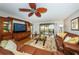 Bright living room featuring a large leather couch, stylish fan, and sliding door to the ocean-view balcony at 4450 Gulf Blvd # 110, St Pete Beach, FL 33706