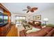 Bright living room featuring a large leather couch, stylish fan, and sliding door to the ocean-view balcony at 4450 Gulf Blvd # 110, St Pete Beach, FL 33706