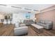 Cozy living room featuring modern decor, wood-paneled accent wall, and an open layout connected to the kitchen at 4450 Gulf Blvd # 110, St Pete Beach, FL 33706