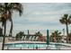 Inviting pool area with lounge chairs and tables overlooking the beach and ocean at 4450 Gulf Blvd # 110, St Pete Beach, FL 33706