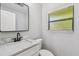 Contemporary bathroom featuring a white vanity with marble countertop and a mirror, complemented by modern fixtures and finishes at 4522 S Hale Ave, Tampa, FL 33611