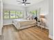 Calming bedroom featuring wood floors, a ceiling fan, and shuttered windows at 4522 S Hale Ave, Tampa, FL 33611