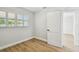 Simple, modern bedroom with wood-look floors and white trim, highlighted by a window and minimalist decor at 4522 S Hale Ave, Tampa, FL 33611