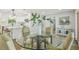 Dining room with a modern glass table, upholstered chairs, and views into the kitchen and entry hall at 4522 S Hale Ave, Tampa, FL 33611