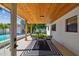Covered patio features a dining area, a striped rug, and a view of the pool and backyard at 4522 S Hale Ave, Tampa, FL 33611