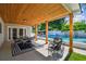 Outdoor patio features a dining area, stylish rug, comfortable seating, and a view of the sparkling pool at 4522 S Hale Ave, Tampa, FL 33611