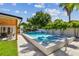 Lush backyard oasis featuring a pristine pool, spa, patio with dining area, and mature tropical landscaping at 4522 S Hale Ave, Tampa, FL 33611