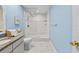 Bright bathroom with blue walls, granite countertop, and walk-in shower with glass door at 6051 65Th N Ave, Pinellas Park, FL 33781