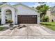 Close up view of a two-car garage with brown door and well-maintained driveway at 6051 65Th N Ave, Pinellas Park, FL 33781