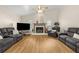 Bright living room featuring a fireplace, hardwood floors, and comfortable grey sofas at 6051 65Th N Ave, Pinellas Park, FL 33781