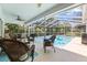 Relaxing screened-in patio with comfortable seating area overlooking the sparkling pool at 6051 65Th N Ave, Pinellas Park, FL 33781