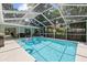 Beautiful screened-in pool with clear blue water and lush backyard at 6051 65Th N Ave, Pinellas Park, FL 33781