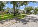 A peaceful street view of a single-story home with mature trees and well-kept lawns at 6051 65Th N Ave, Pinellas Park, FL 33781