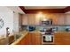 Well-lit kitchen featuring stainless steel appliances, granite countertops, and wooden cabinetry at 6105 Bahia Del Mar Cir # 682, St Petersburg, FL 33715