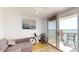 Bright living room featuring a gray sofa, bike and sliding glass doors to a balcony with water views at 6105 Bahia Del Mar Cir # 682, St Petersburg, FL 33715