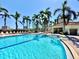 Community pool with a blue line, featuring lounge chairs, palm trees, and access to the building at 6105 Bahia Del Mar Cir # 682, St Petersburg, FL 33715