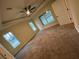 Large bedroom features plush carpeting, a ceiling fan, and tray ceilings for added elegance at 6153 La Pine Rd, Brooksville, FL 34602