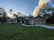 Charming single-Gathering home with a two-car garage, lush green lawn, and mature trees at 6153 La Pine Rd, Brooksville, FL 34602